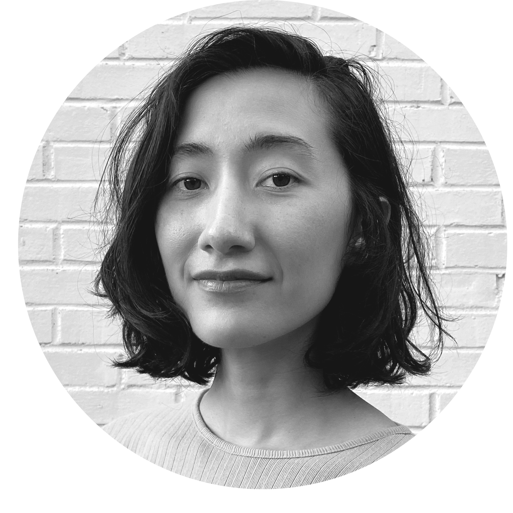 black and white headshot of a woman with olive skin and chin-length brown wavy hair