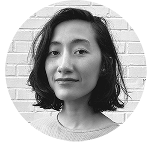 Home black and white headshot of a woman with olive skin and chin-length brown wavy hair
